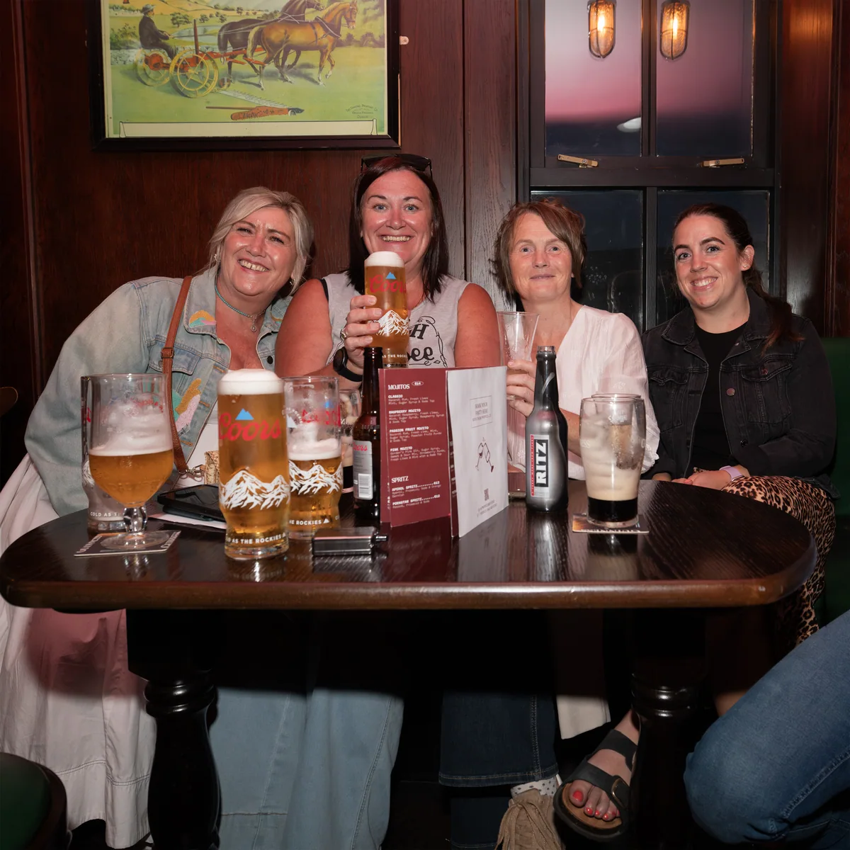 Four guests sitting together around a table during a Thursday evening at T. Morris.